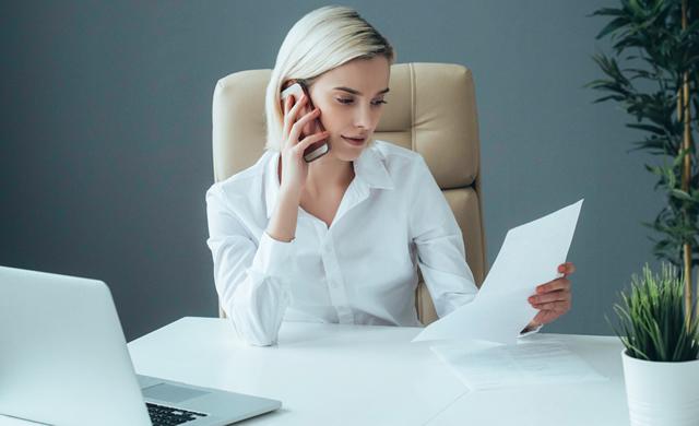 businesswoman sitting at desk on phone